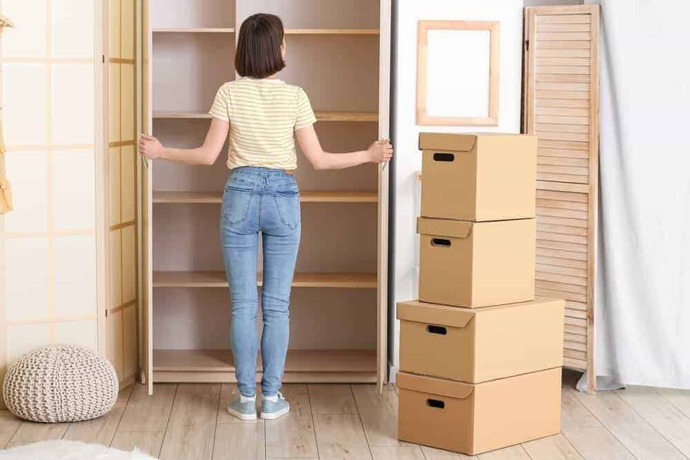 Eine Frau steht vor einem leeren Schrank nach einer Haushaltsauflösung